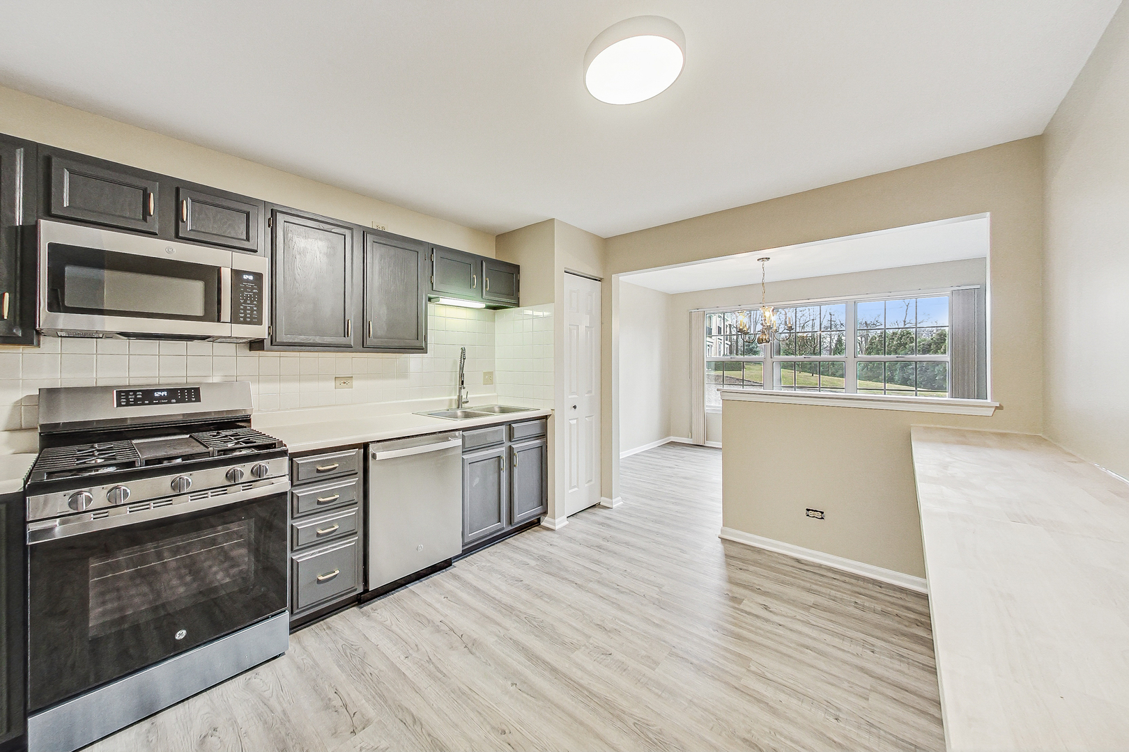 1006 Butternut Lane, Unit B Mount Prospect, IL 60056 - Photo 6 of 26 a kitchen with granite countertop wooden floors and stainless steel appliances
