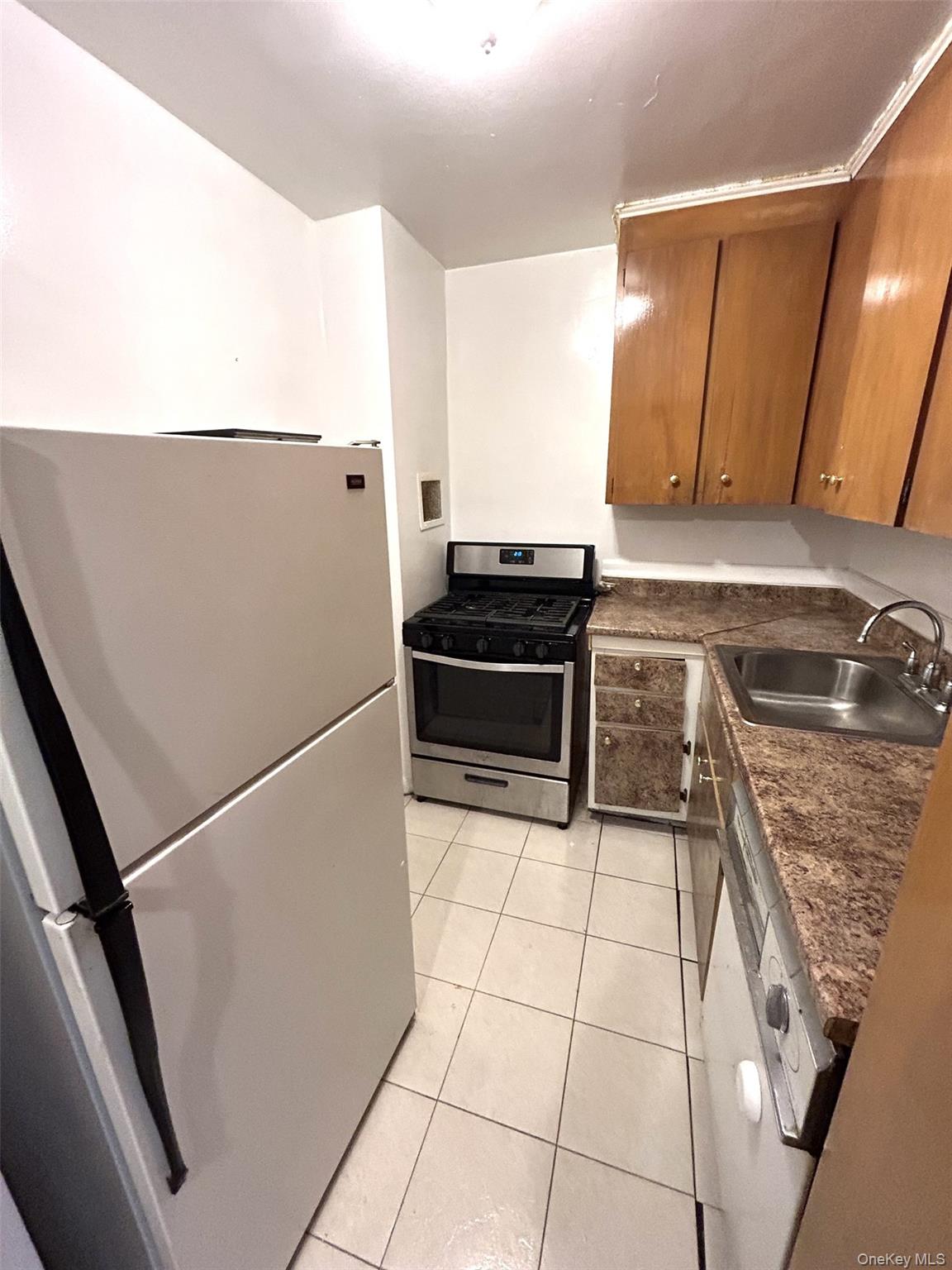 81-11 45th Avenue, Unit 3 Queens, NY 11373 - Photo 6 of 9 a kitchen with a refrigerator and a stove top oven