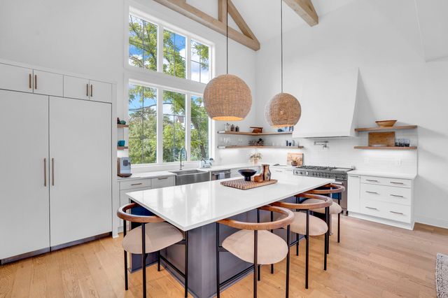a dining hall with stainless steel appliances granite countertop a sink and a refrigerator