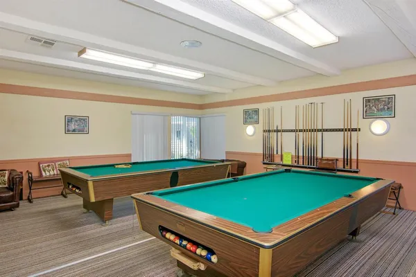 a room with pool table and windows