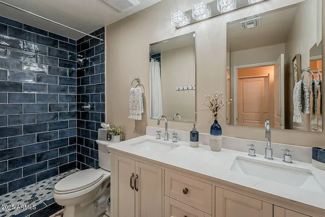 a bathroom with a sink a toilet a mirror and shower