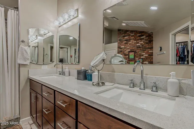 a bathroom with double vanity sinks and a mirror