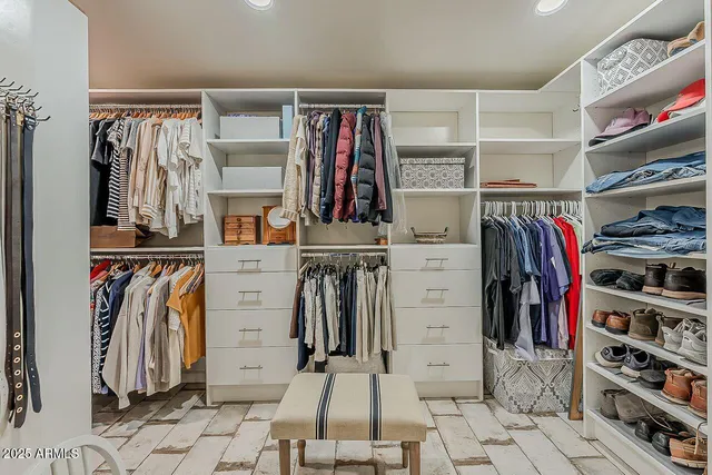 a view of walk in closet with clothes and shoes