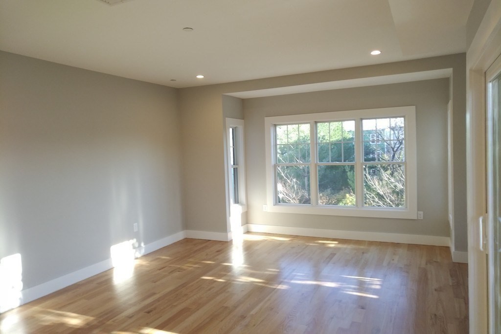 186 Havre Street, Unit 4 Boston, MA 02128 - Photo 4 of 16 a view of empty room with wooden floor and fan