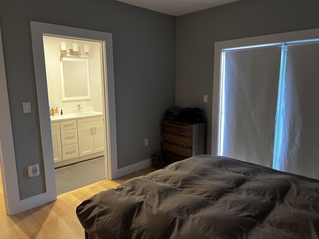 186 Havre Street, Unit 4 Boston, MA 02128 - Photo 5 of 16 a bedroom with a bed and wooden floor