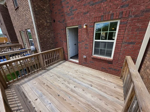 a view of balcony with wooden floor and fence
