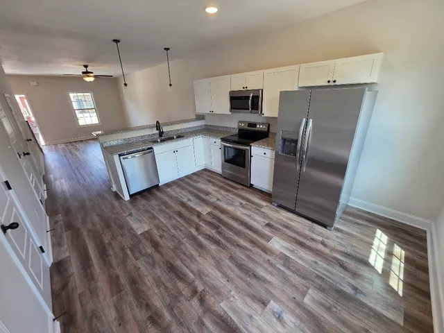 a kitchen with stainless steel appliances a refrigerator sink and microwave