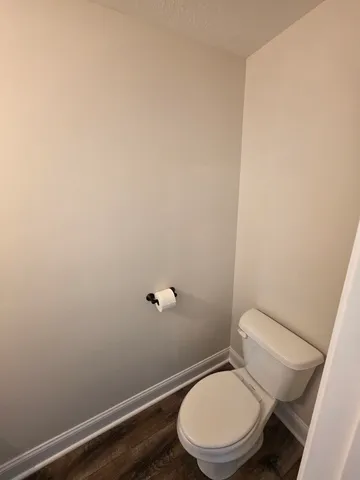 a white toilet sitting next to a shower