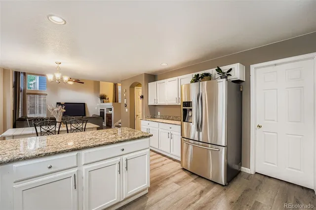 a kitchen with granite countertop a refrigerator and a sink