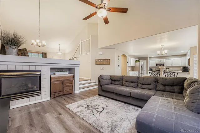 a living room with furniture a fireplace and a chandelier