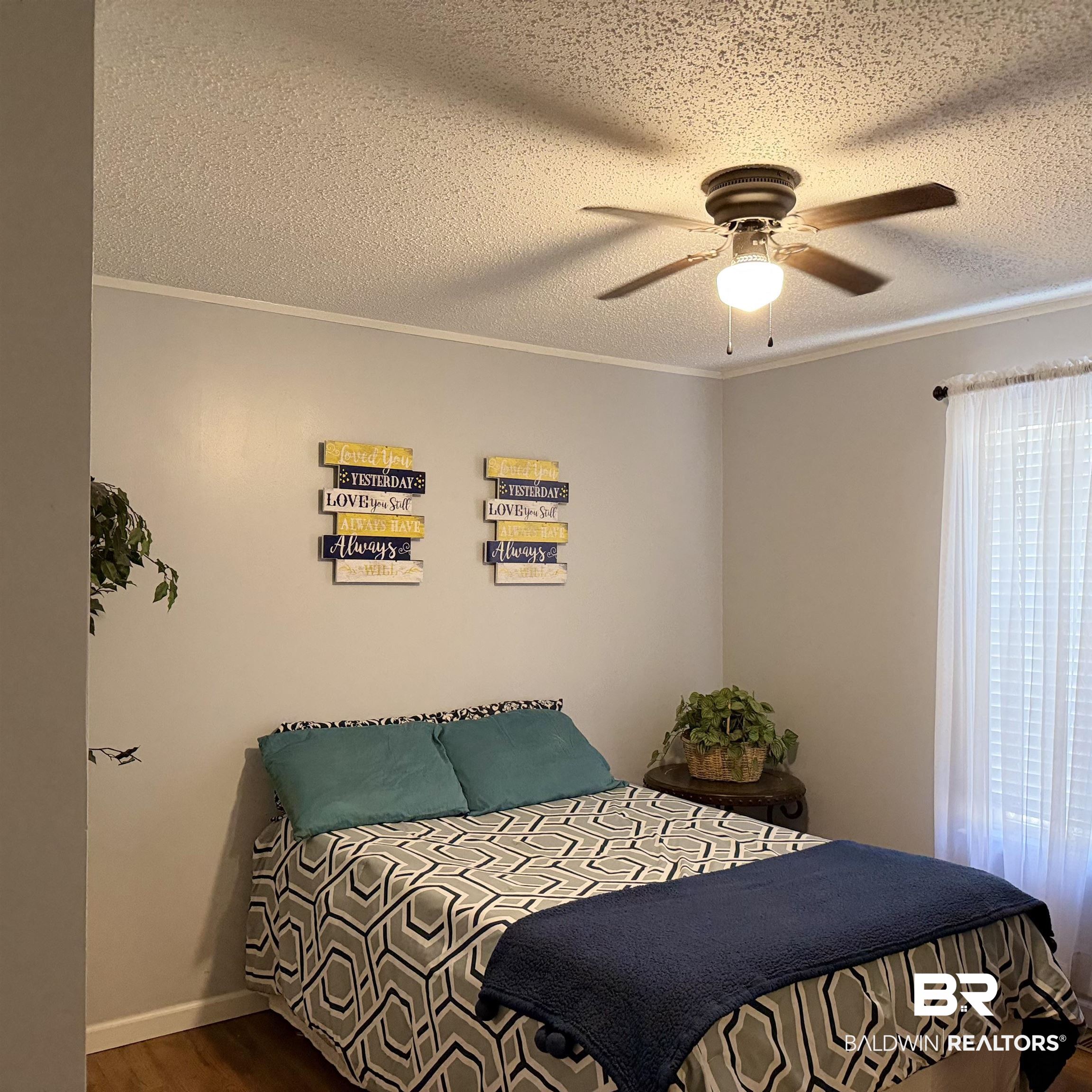 447 Sugar Hill Road Monroeville, AL 36460 - Photo 15 of 27 Bedroom with wood finished floors, a textured ceiling, a ceiling fan, and ornamental molding