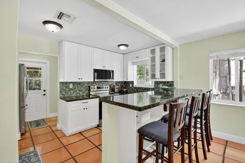 a kitchen with granite countertop a sink stove and cabinets