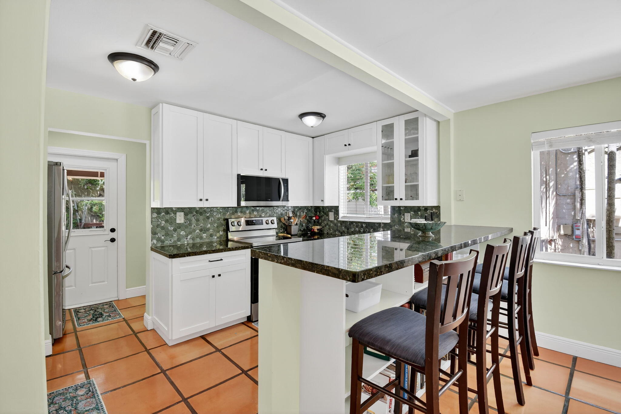 1309 Southwest 19th Avenue Fort Lauderdale, FL 33312 - Photo 15 of 66 a kitchen with stainless steel appliances kitchen island granite countertop a dining table chairs and granite counter tops