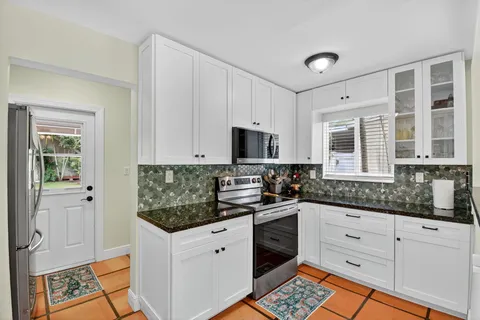 a kitchen with stainless steel appliances kitchen island granite countertop a stove and a sink
