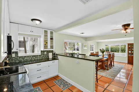 a view of a refrigerator in kitchen and an empty room