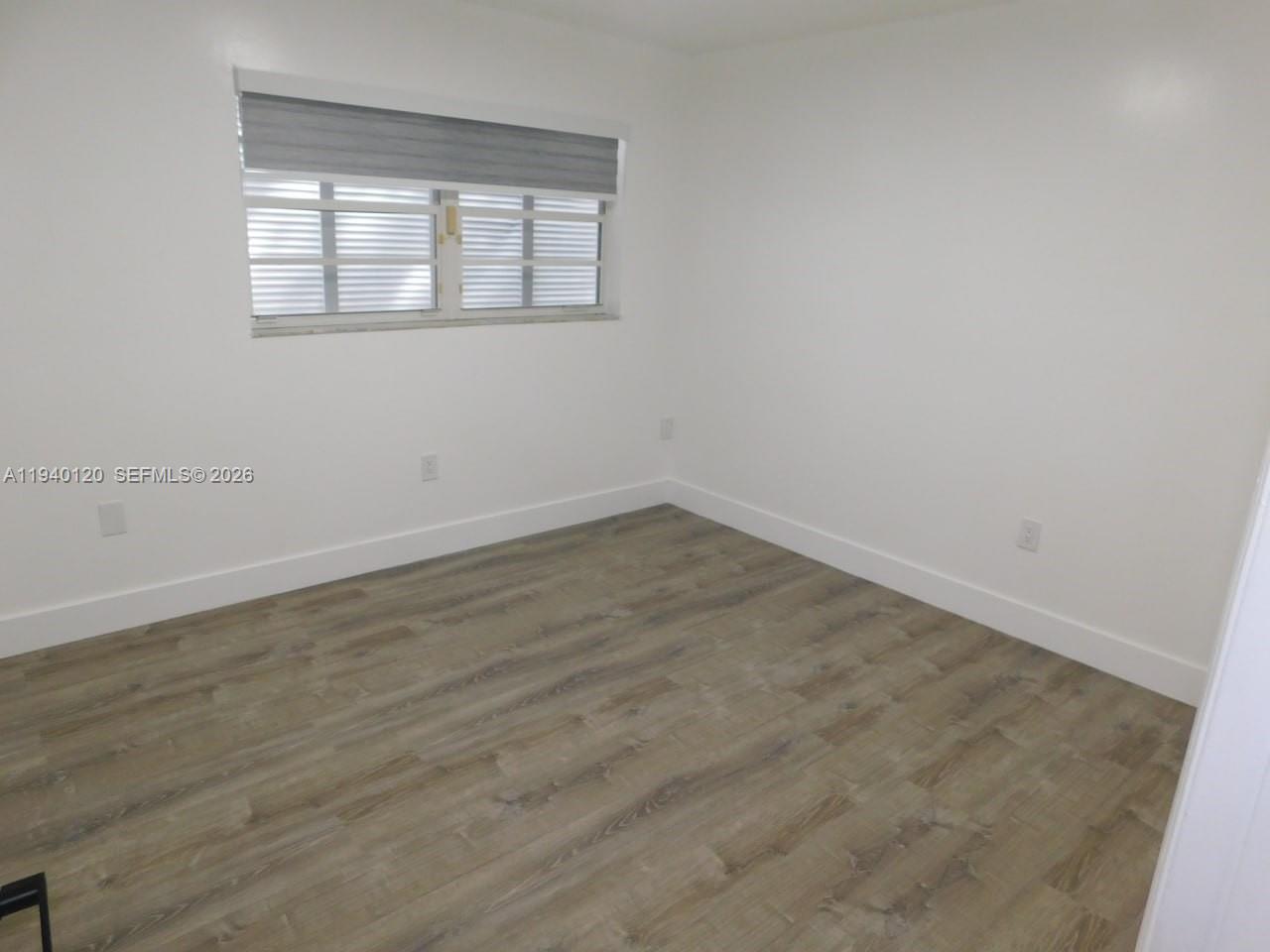 16240 Southwest 286th Street Homestead, FL 33033 - Photo 17 of 25 an empty room with wooden floor and windows