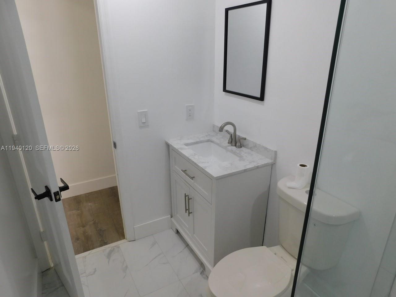 16240 Southwest 286th Street Homestead, FL 33033 - Photo 24 of 25 a bathroom with a sink and mirror with toilet