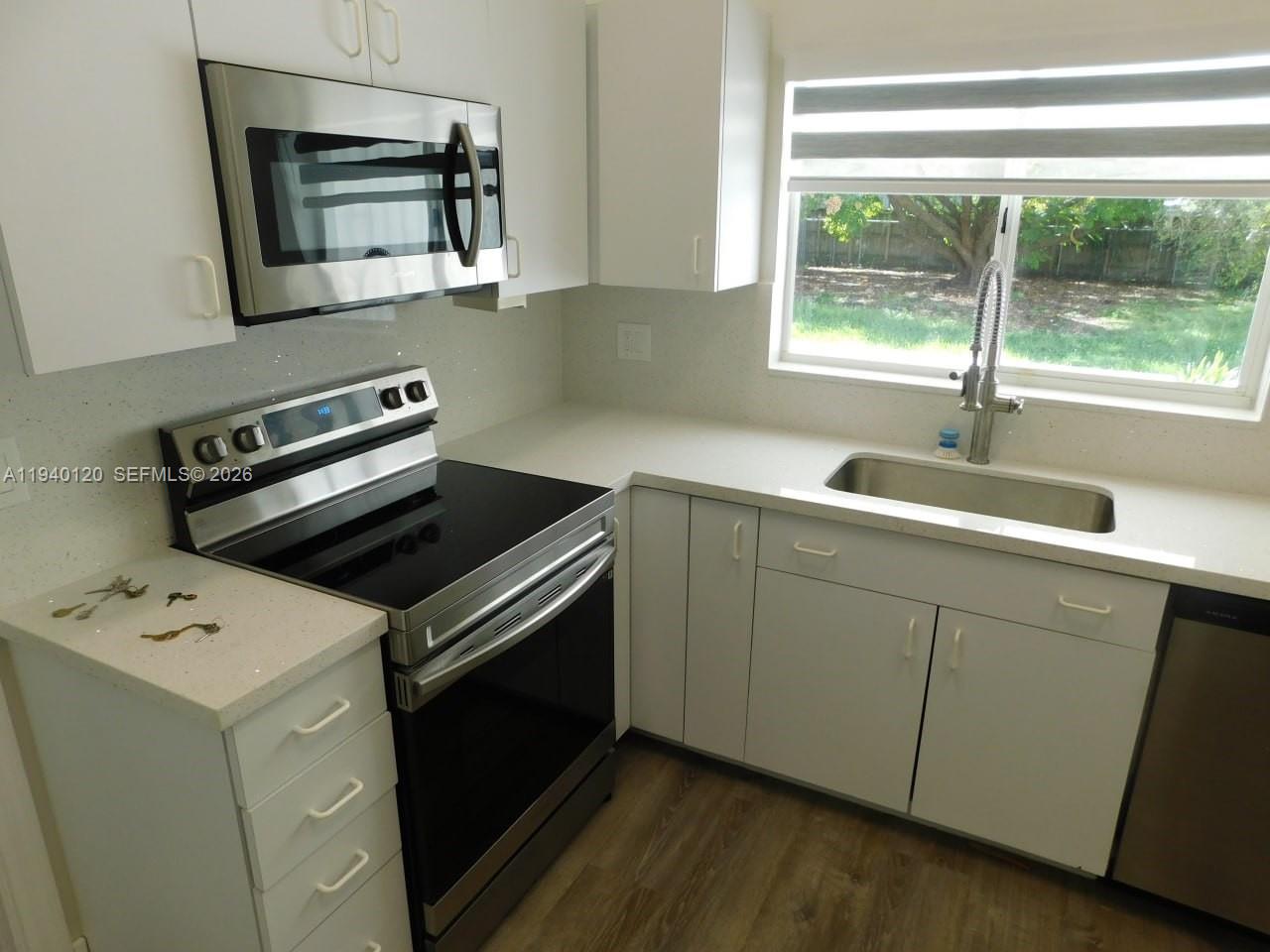 16240 Southwest 286th Street Homestead, FL 33033 - Photo 3 of 25 a kitchen with a stove microwave and a sink
