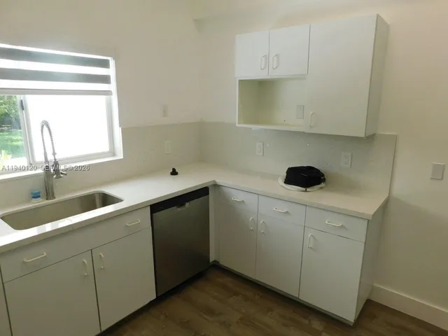 a kitchen with a sink cabinets and a window