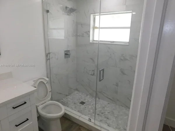 a bathroom with a shower a toilet and a sink