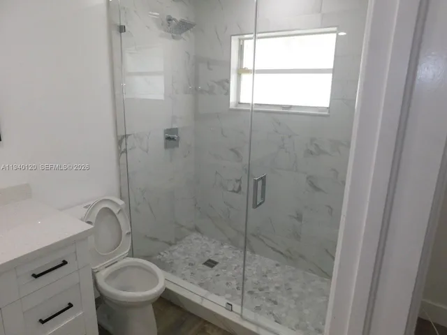 a bathroom with a shower a toilet and a sink