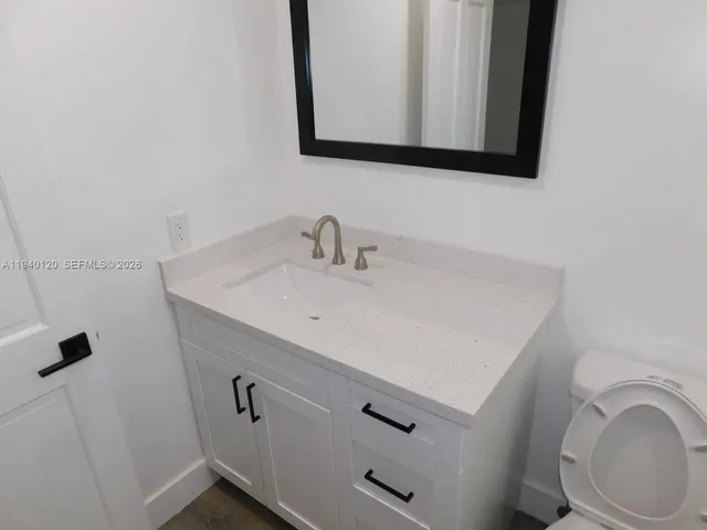 a bathroom with a sink a toilet and mirror