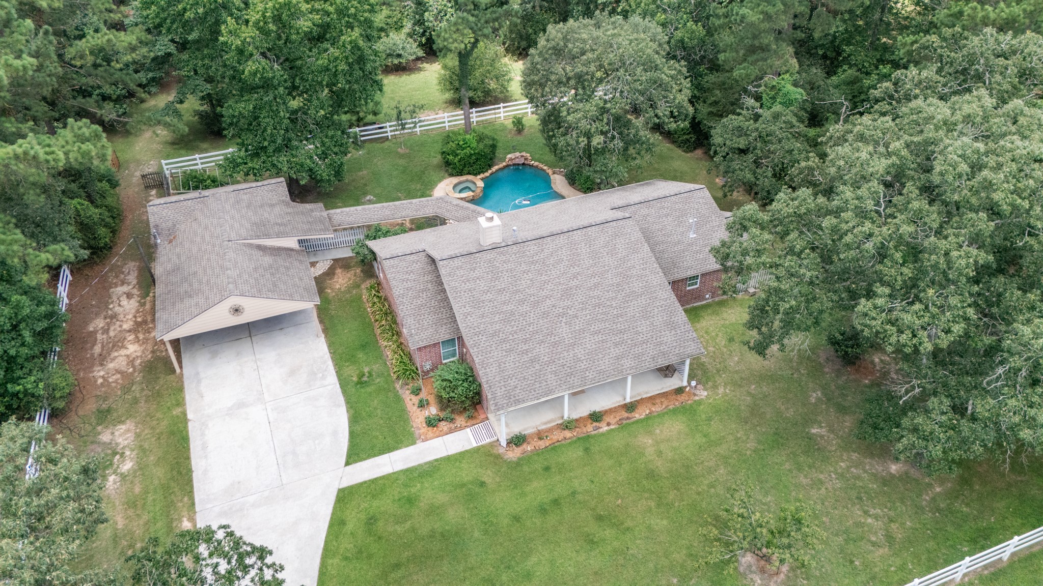 20203 Timber Ridge Drive Magnolia, TX 77355 - Photo 47 of 49 Welcome to your own private retreat, where timeless charm meets everyday comfort. Nestled among mature trees on a beautifully landscaped lot, this custom brick home offers exceptional privacy, generous outdoor living, and a resort-style backyard designed for relaxation and entertaining.