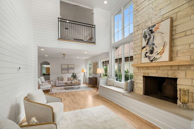 a dining room with furniture large windows and wooden floor