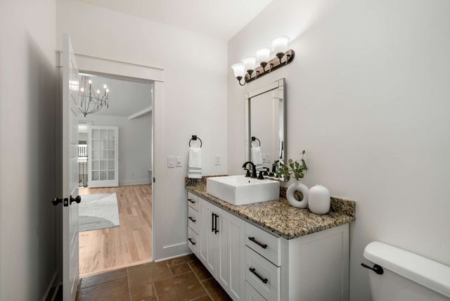 a bathroom with a granite countertop sink and a mirror