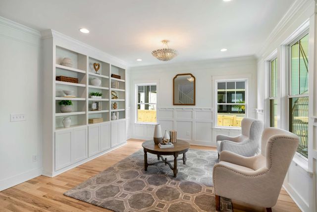 a kitchen with stainless steel appliances granite countertop a stove top oven a sink dishwasher a refrigerator and white cabinets with wooden floor