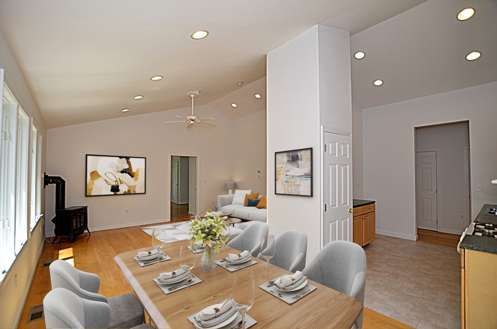 a living room with furniture kitchen view and a wooden floor