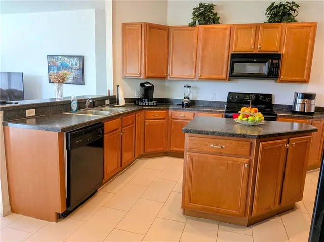 a living room with stainless steel appliances furniture and a flat screen tv