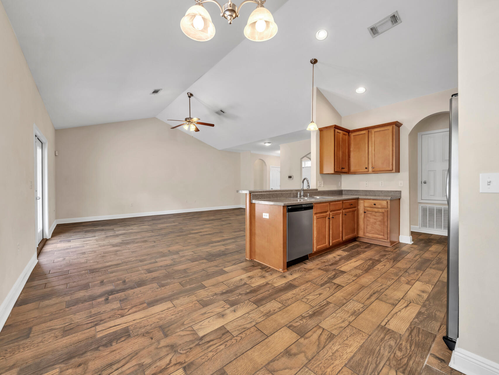 612 Rowan Circle Crestview, FL 32536 - Photo 12 of 32 a large kitchen with kitchen island a sink dishwasher a stove and a refrigerator with wooden floor