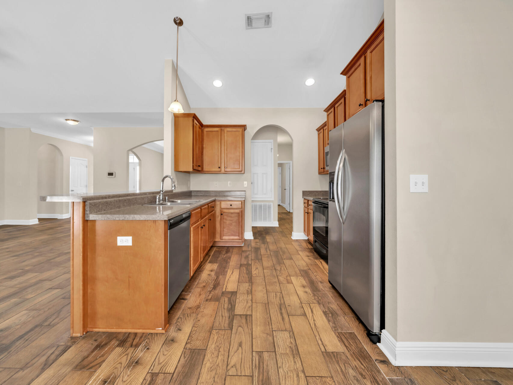 612 Rowan Circle Crestview, FL 32536 - Photo 13 of 32 a large kitchen with stainless steel appliances granite countertop a lot of cabinets and wooden floor