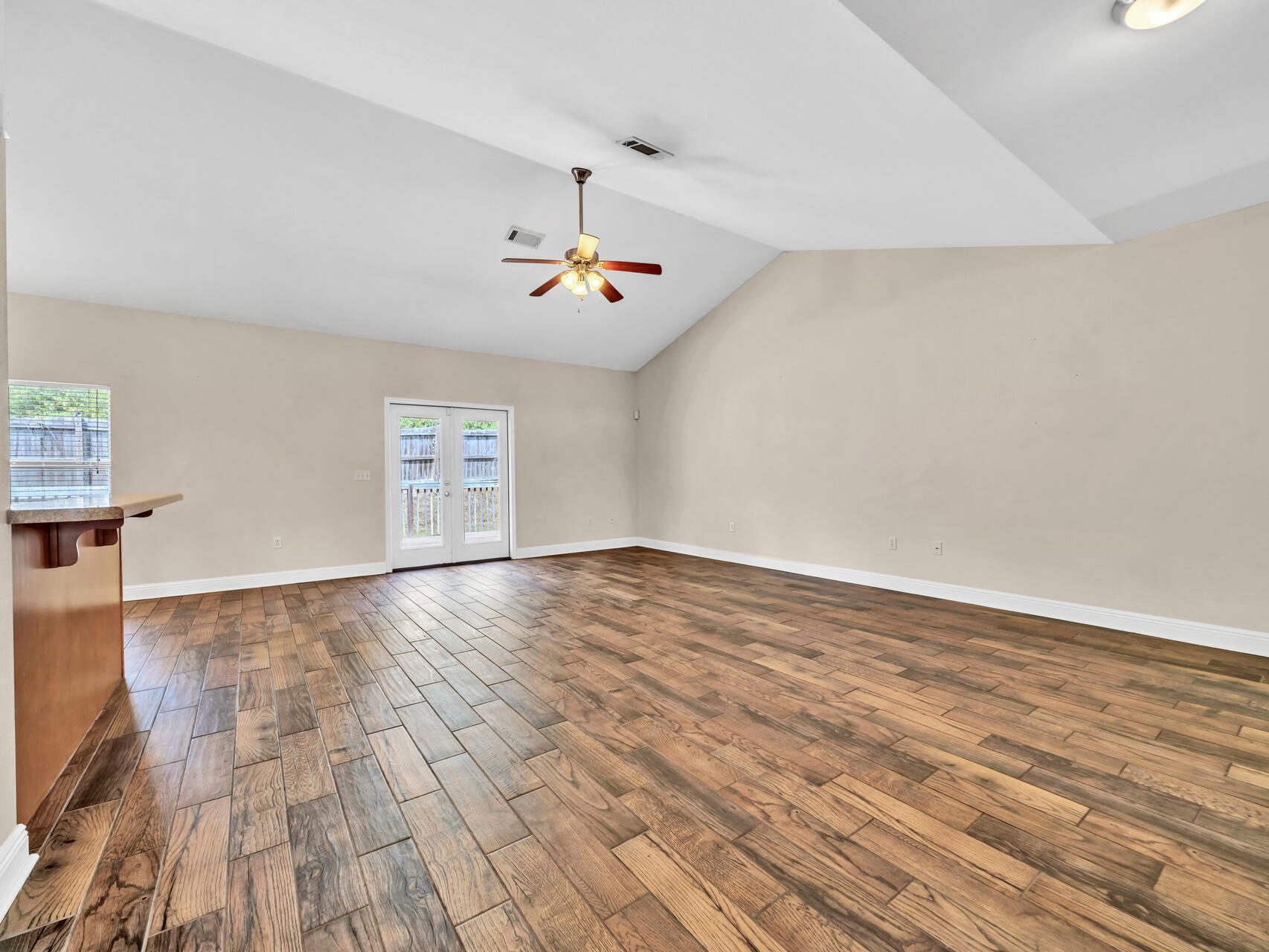 612 Rowan Circle Crestview, FL 32536 - Photo 7 of 32 an empty room with wooden floor and windows