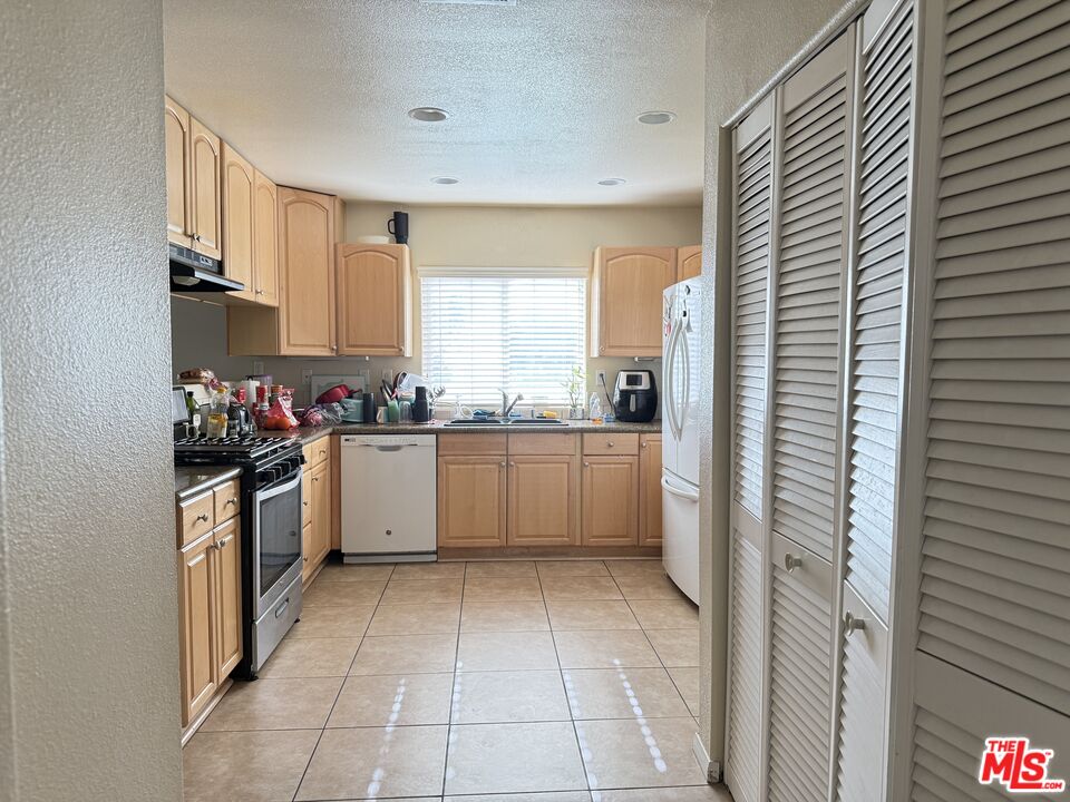 18238 Kalin Ranch Drive Victorville, CA 92395 - Photo 12 of 33 a kitchen with a white cabinets and white appliances