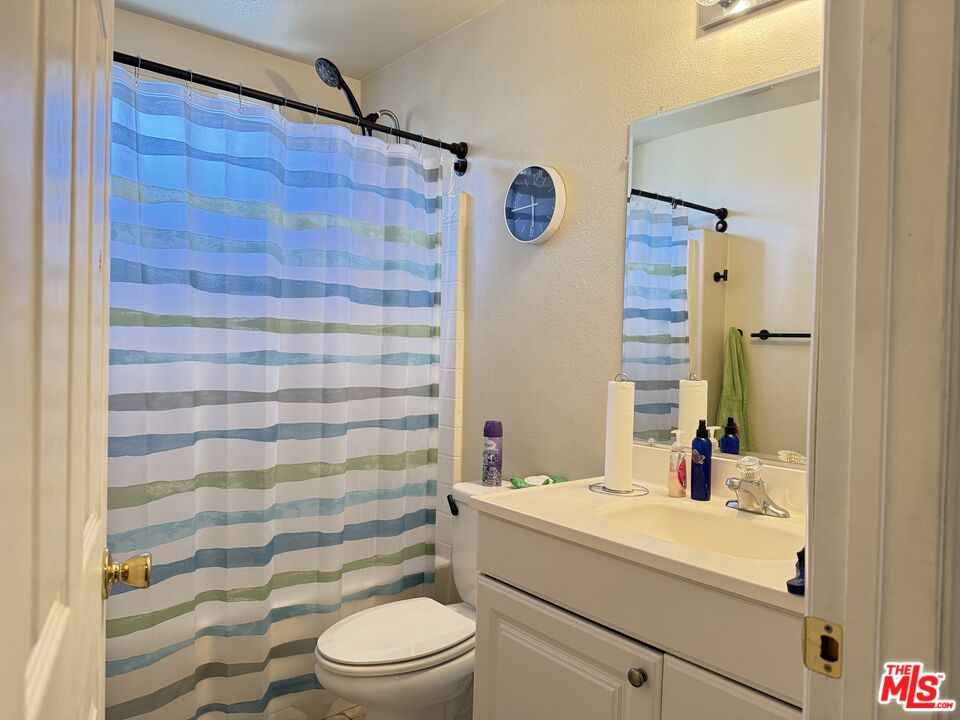 18238 Kalin Ranch Drive Victorville, CA 92395 - Photo 23 of 33 a bathroom with a sink a toilet and shower curtain