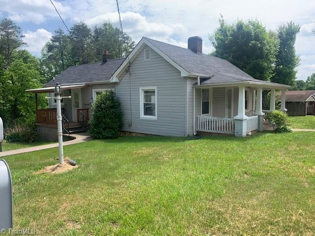 side view from driveway with sidewalk and covered porch