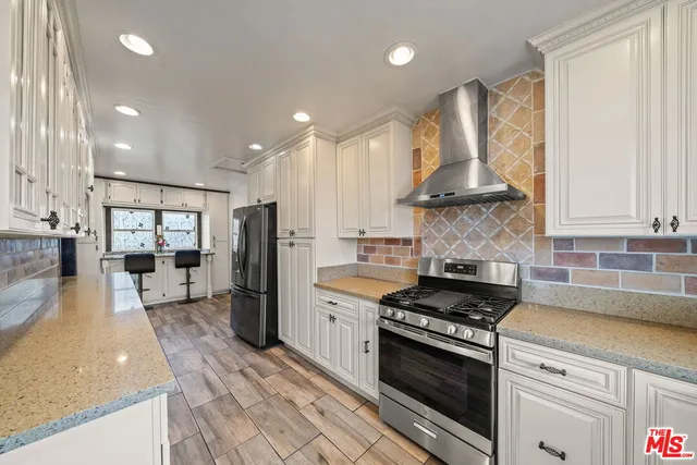 a kitchen with stainless steel appliances granite countertop a stove a refrigerator and a sink
