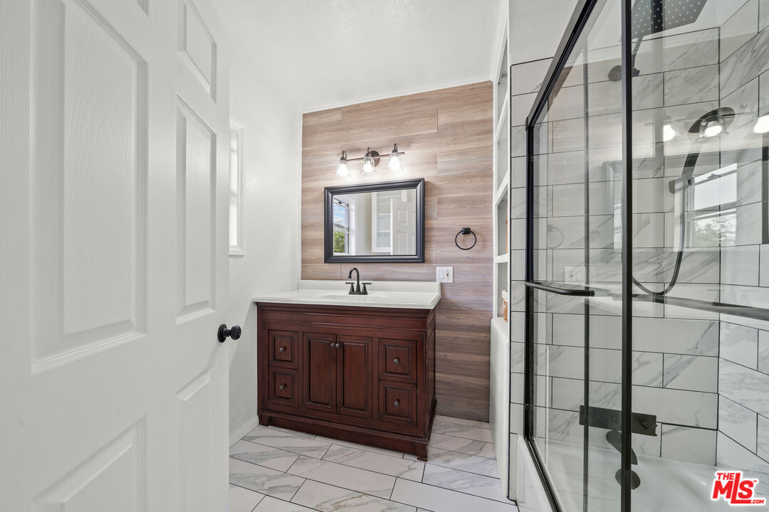 5732 6th Avenue Los Angeles, CA 90043 - Photo 17 of 22 a bathroom with a sink a mirror and shower