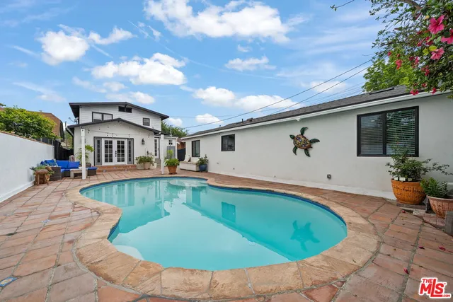 a view of a house with swimming pool and a yard