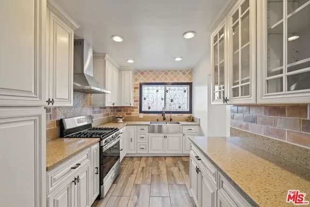 a kitchen with a sink stove top oven and cabinets
