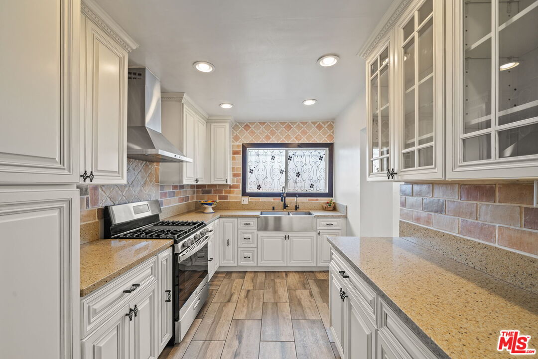 5732 6th Avenue Los Angeles, CA 90043 - Photo 10 of 22 a kitchen with a sink stove top oven and cabinets