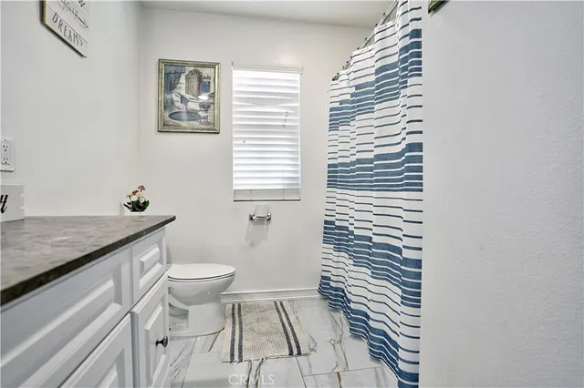 a kitchen with kitchen island granite countertop wooden cabinets a sink a stove a oven with dining table and chairs