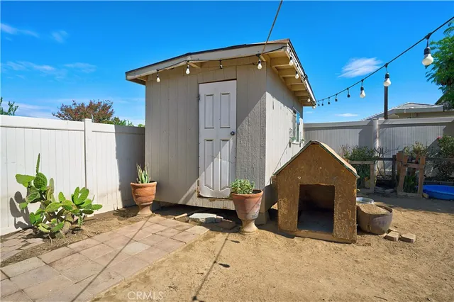a view of a backyard with table and chairs potted plants and tree
