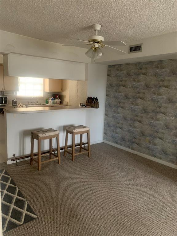 500 Newell Hill Road, Unit 104C Leesburg, FL 34748 - Photo 13 of 15 a living room with stainless steel appliances kitchen island granite countertop furniture and a fireplace