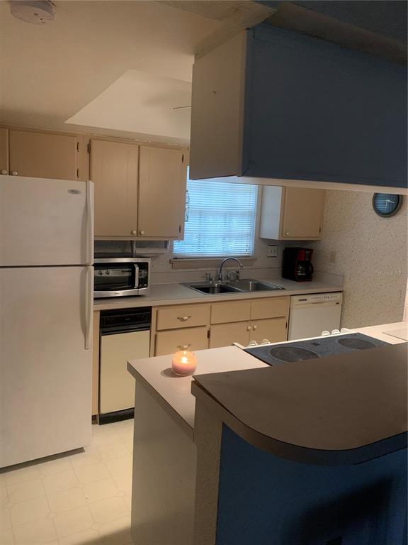 500 Newell Hill Road, Unit 104C Leesburg, FL 34748 - Photo 3 of 15 a kitchen with a sink a stove and a refrigerator