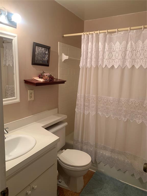 500 Newell Hill Road, Unit 104C Leesburg, FL 34748 - Photo 9 of 15 a bathroom with a sink a toilet and shower curtain