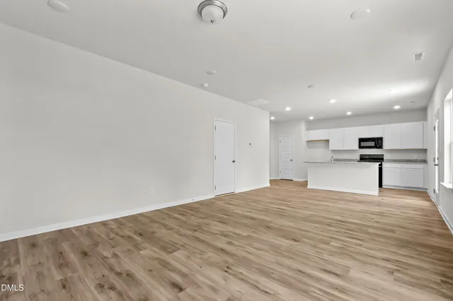 a view of kitchen with kitchen island white cabinets and wooden floor