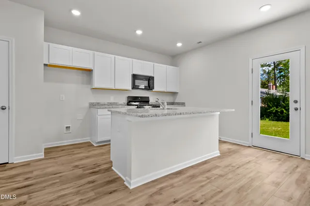 a kitchen with stainless steel appliances granite countertop a refrigerator a stove a sink and a microwave